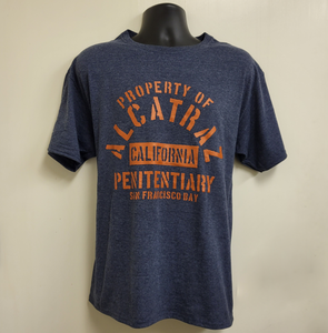 A heather navy color tee shirt with "Property of Alcatraz Penitentiary California San Francisco Bay" logo on the front.