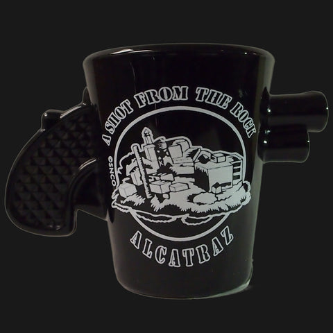 A pistol shape shot glass with "A Shot From The Rock Alcatraz" on the side of the shot glass.