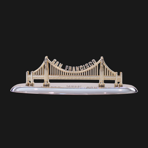 A gold color model of the Golden Gate Bridge on a stand.