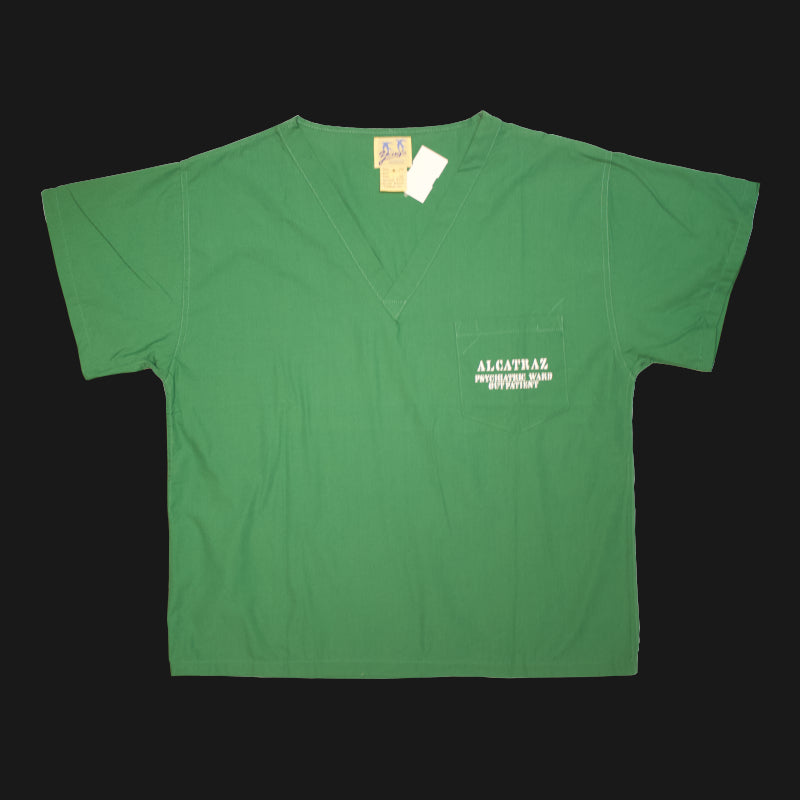 A green v-neck scrub short sleeves shirt with "Alcatraz psychiatric ward outpatient" on the left chest pocket.