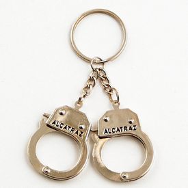 A chrome color mini handcuff keychain with "Alcatraz" on the cuffs. 